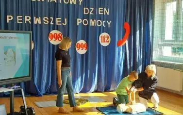 Uczeń z klasy IV prezentuje uciskanie klatki piersiowej na manekinie