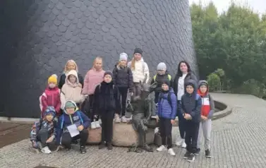 Uczniowie przy pomniku  Koziołka Matołka w Pacanowie - zdjęcie grupowe.