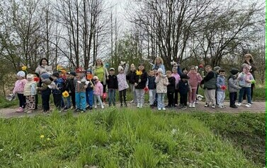Przedszkolaki na spacerze połączonym z rozdawaniem kwiat&oacute;w ekologicznych.