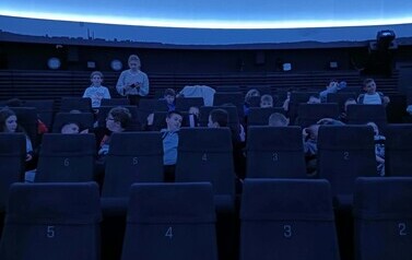 Uczniowie przed seansem w sali projekcyjnej Planetarium Śląskiego
