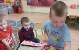 Dzieci wykrawały walentynkowe ciasteczka w kształcie serca za pomocą foremek.