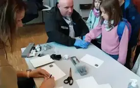 Warsztaty z daktyloskopii - uczniowie odbijają odciski swoich dłoni.