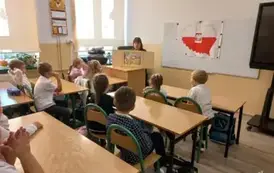 Pani bibliotekarka czyta dzieciom legendę za pomocą teatrzyku kamishibai