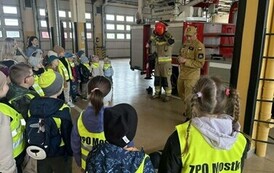 Przedszkolaki słuchają pogadanki na temat odpowiedzialnej służby strażaka.