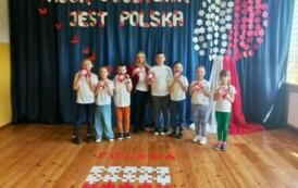 Zdjęcie uczni&oacute;w z panią Anią z  kotylionami i z flagą zrobioną z puzzli