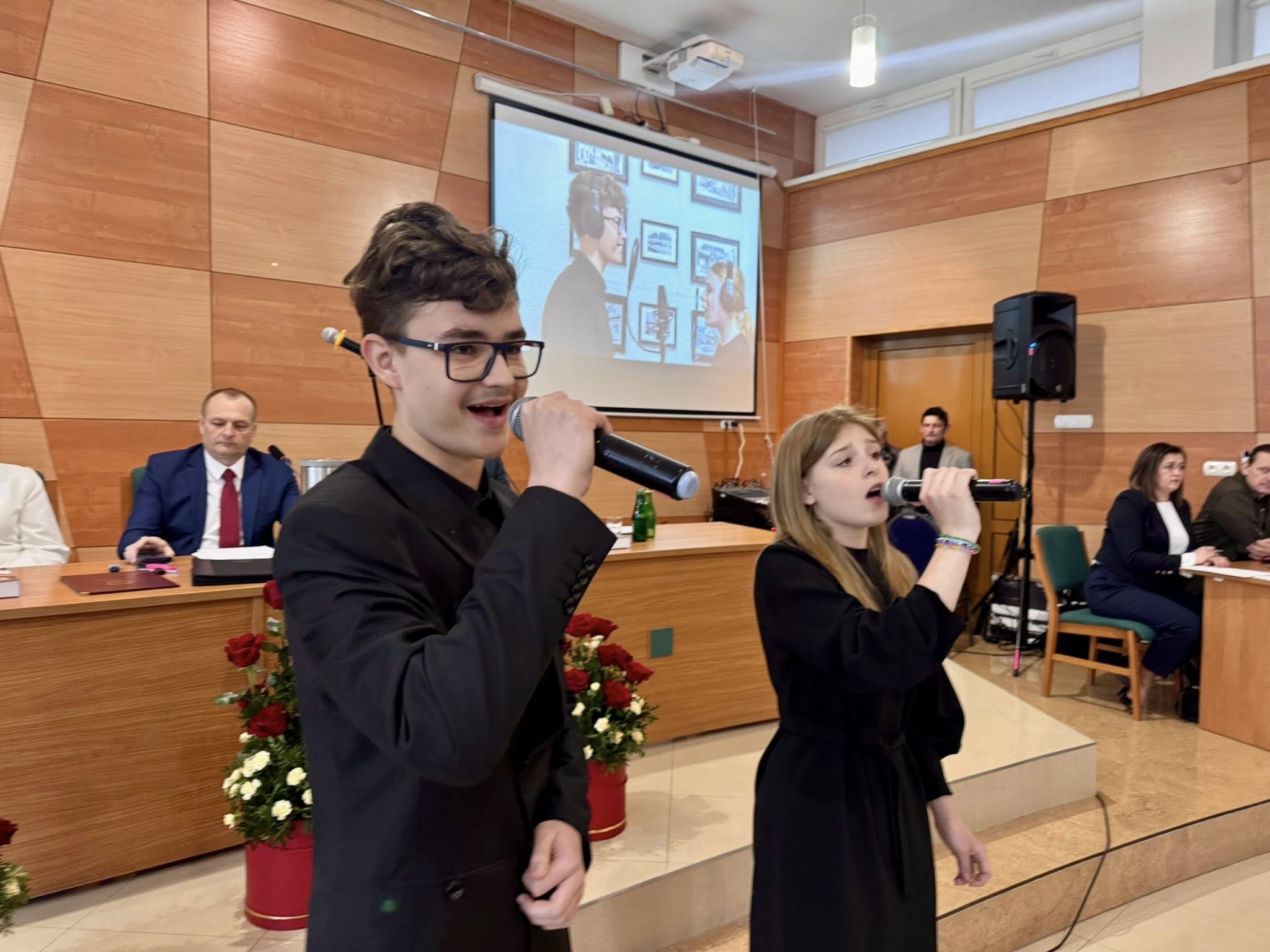 Roksana i&nbsp;Jaromir śpiewają piosenkę "Stasz&oacute;w - moje miasto" podczas sesji Rady Miejskiej w&nbsp;Staszowie
