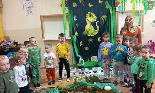Wspólne zdjęcie na tle dinozaurów.