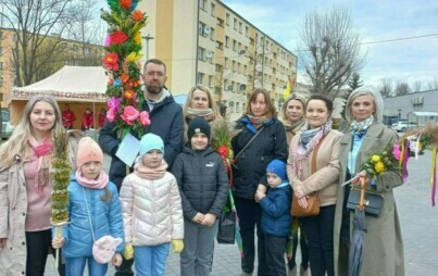 Uczniowie, rodzice i nauczyciele z palmą wielkanocną